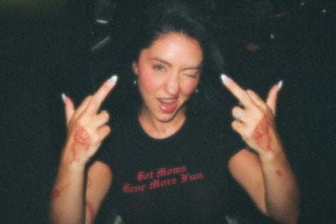 Person making a peace sign with both hands in a dark setting
