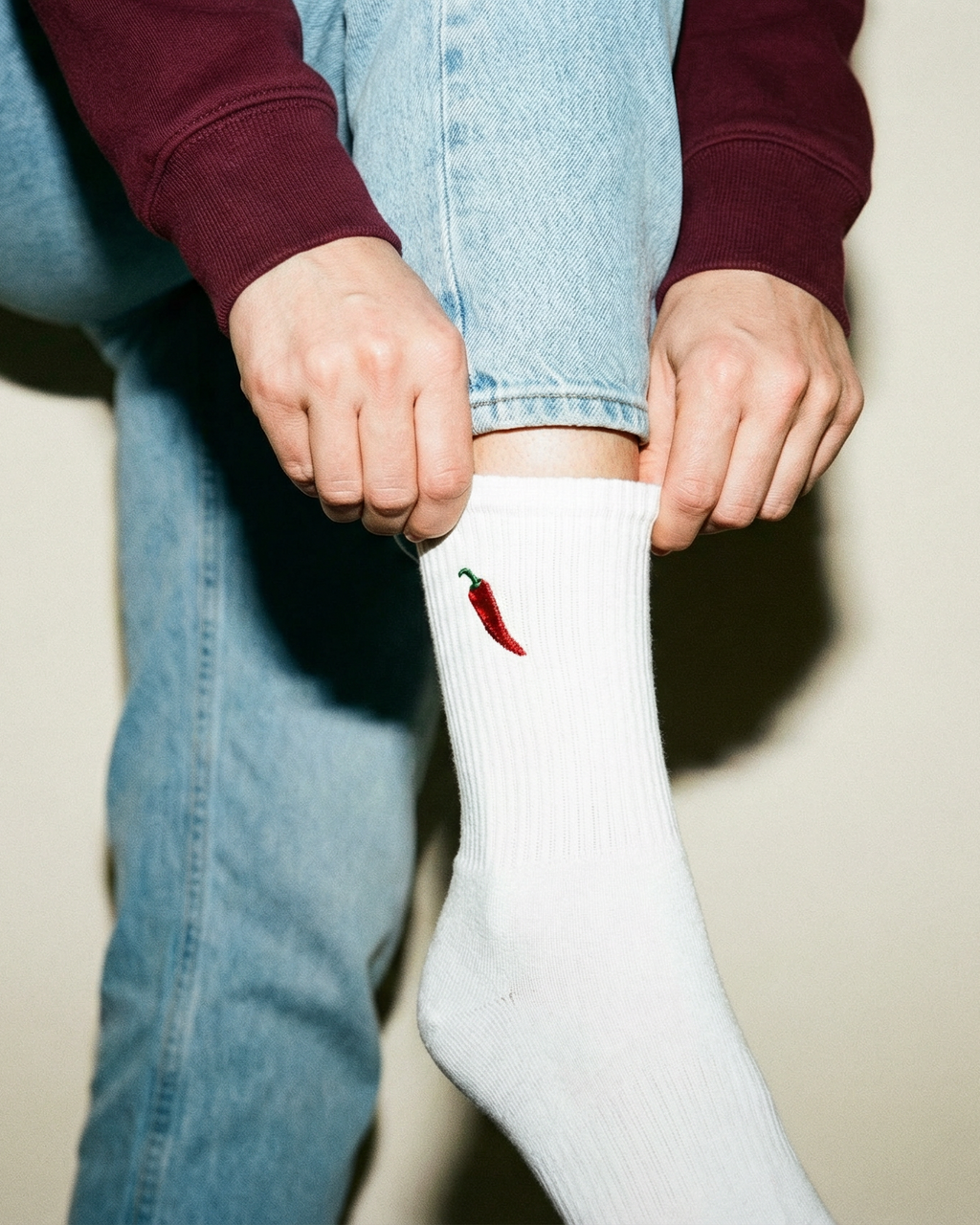 Person wearing white socks with a red chili pepper design