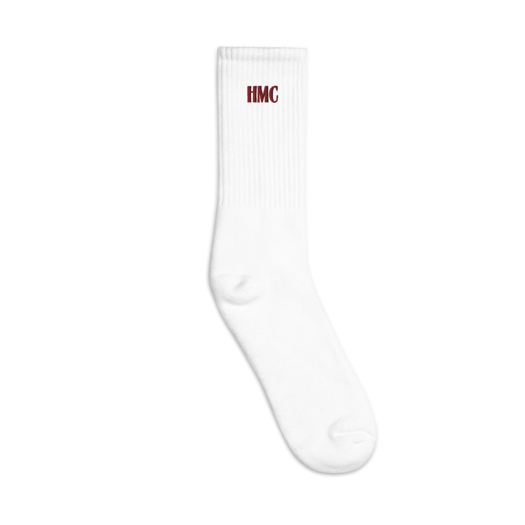 Left facing mockup of white crew socks with burgundy embroidery logo HMC